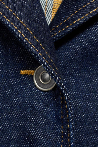 Jean de MANGO en denim bleu foncé, avec un nœud argenté et des points dorés.