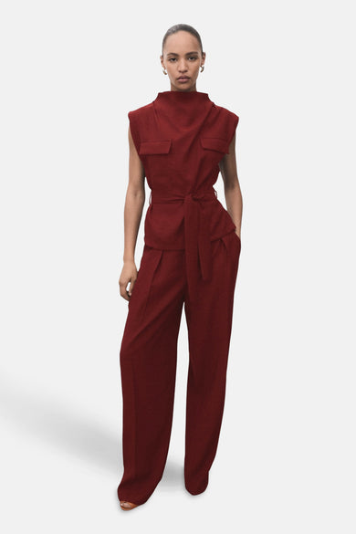 Bordeaux blouse zonder mouwen van MANGO, met opstaande kraag en riem, gecombineerd met een bijpassende broek.