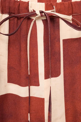 Multikleurige broek van MANGO, met een opvallend grafisch blokpatroon en een gestrikt detail aan de tailleband.
