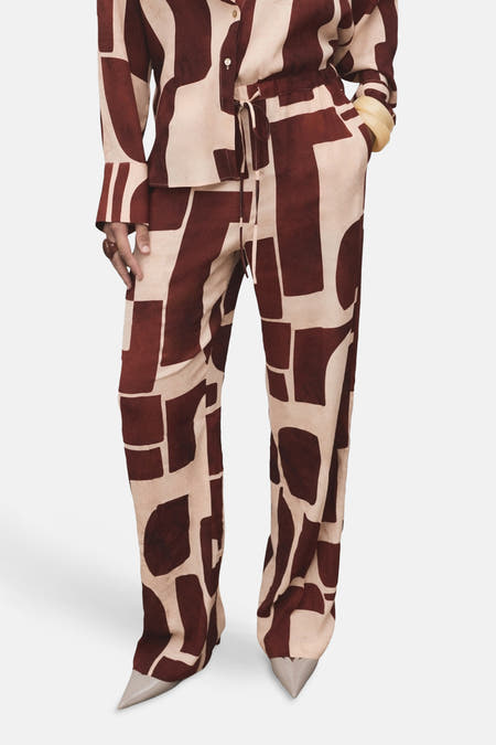 Multikleurige broek van MANGO met een abstract blokpatroon en puntige schoenen.
