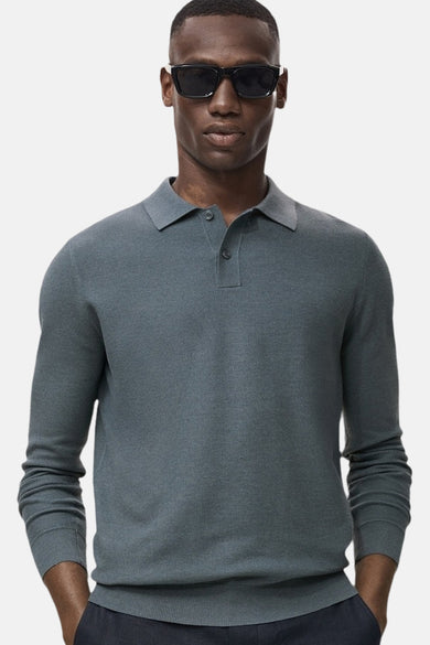 Groene trui met ronde hals van MANGO, gedragen met een donkere broek en zonnebril.
