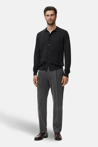 Grijs gilet van MANGO, gedragen over een donker shirt en grijze pantalon met bruine schoenen.
