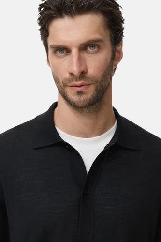Gilet bleu de MANGO porté sur un T-shirt blanc.