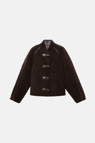 Manteau court marron de MANGO, avec texture en fourrure Teddy, finition en cuir et fermeture à boutons.