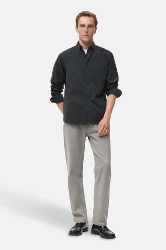 Grijs, lange mouwen overhemd van MANGO, met knoopsluiting, gedragen met een wit T-shirt, grijze jeans en zwarte schoenen.
