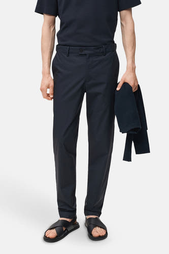 Blauwe broek van MANGO, gedragen met een blauw shirt en zwarte sandalen.
