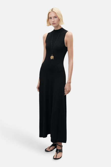 Zwarte mouwloze kleedje van MANGO, met een lange gouden ketting en zwarte sandalen.
