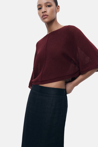 Bordeaux trui met ronde hals van MANGO, gedragen met een zwarte rok.