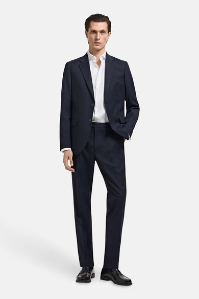 Wit overhemd met lange mouwen van MANGO, gedragen onder een donkerblauw pak met zwarte schoenen.