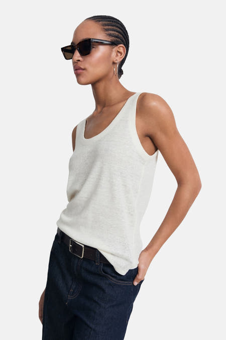 Beige singlet van MANGO, gedragen met een donkere jeans met riem en zonnebril.