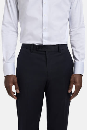 Pantalon de costume bleu MANGO, avec un chemisier à fines rayures.