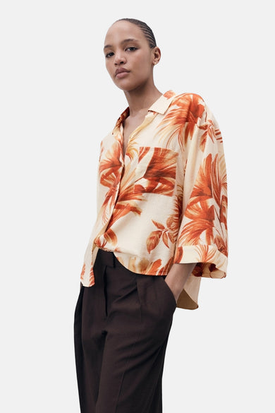 Multicolor hemd met korte mouwen van MANGO, met bladprint en gedragen met een donkere broek.
