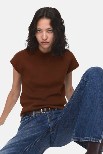Bruine mouwloze top van MANGO, gedragen met een blauwe jeans en een bruine riem.