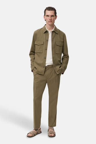 Groen hemd met lange mouwen van MANGO, met opgestikte zakken, gecombineerd met een wit poloshirt en kaki broek.