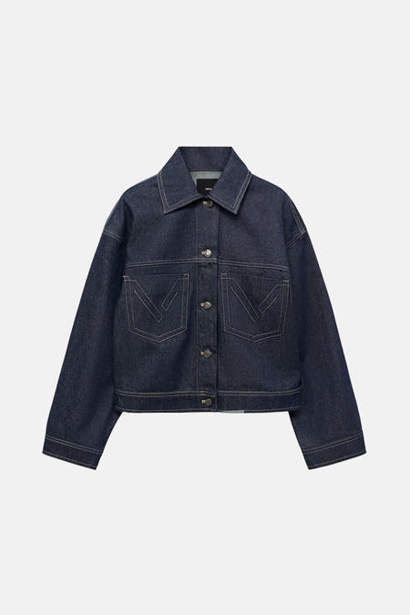 Veste en jeans bleu marine de MANGO, avec des manches longues, une fermeture à boutons et des poches brodées avec des points décoratifs.