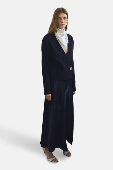 Gilet bleu de MANGO, associé à une longue jupe et un foulard blanc.