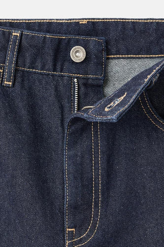 Jean denim bleu marine spécial fit de MANGO, avec fermeture éclair visible et points contrastés.