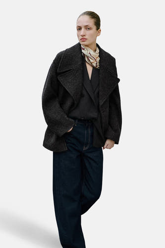 Jean en denim bleu marine spécial fit de MANGO, avec des jambes larges et des coutures légères, associé à une veste grise foncée.