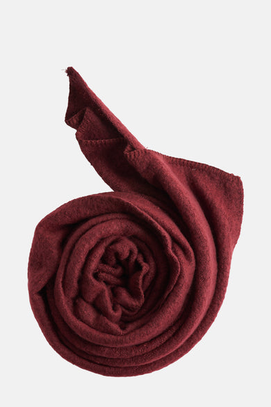 Écharpe d'hiver rouge de PIECES, enroulée dans un motif spiralé avec une douce texture.