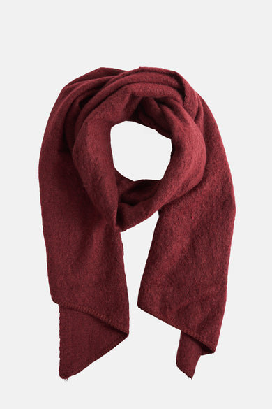 Châle d'hiver rouge de PIECES®, avec une texture tricotée grossière et des extrémités dénouées.