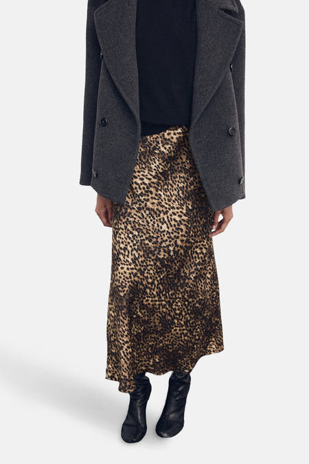 Robe multicolore de MANGO avec un imprimé léopard, associée à une veste grise foncée et des bottes noires.