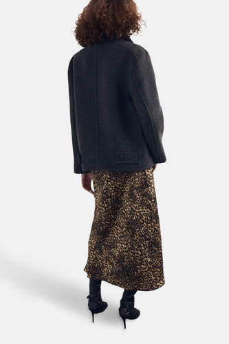 Multikleurige rok van MANGO, met een luipaardprint en gecombineerd met een donkergrijze jas en zwarte laarzen.