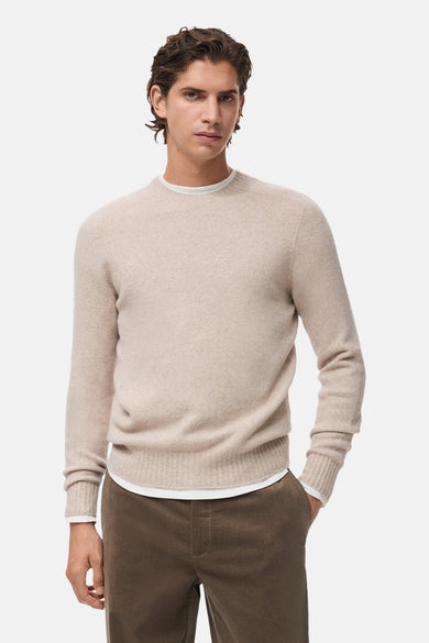 Pull beige à col rond de MANGO, avec des manches longues et un pantalon marron.