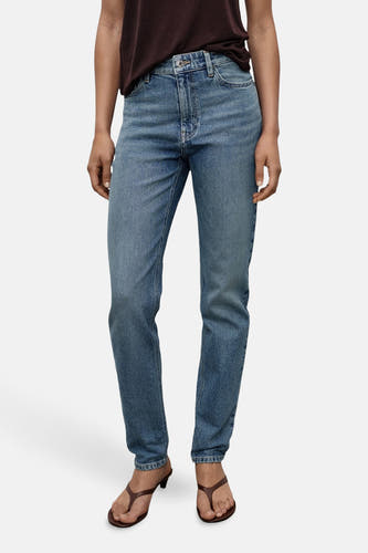 Middenblauwe mom jeans van MANGO, gedragen met bruine teenslippers en een donkerbruin t-shirt.
