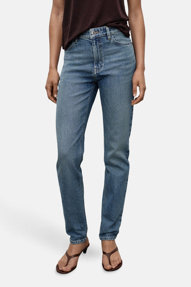 Middenblauwe mom jeans van MANGO, gedragen met bruine teenslippers en een donkerbruin t-shirt.
