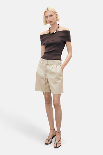Beige bermuda van MANGO, gedragen met een bruine top met blote schouders, zwarte hakken en een ketting.