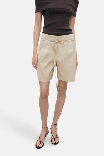 Beige bermuda van MANGO, met trekkoord, gecombineerd met een bruine top en zwarte sandalen.
