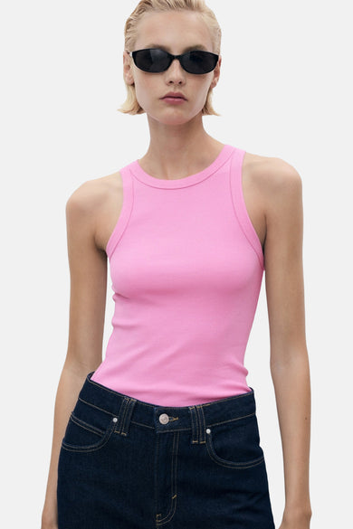 Roze singlet van MANGO, gedragen met een donkere jeans en zonnebril.