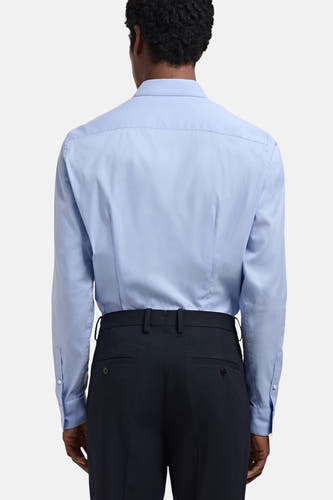 Chemise bleue à manches longues de MANGO, vue de derrière, associée à un pantalon foncé.