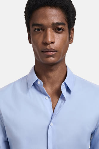 Chemise bleue à manches longues de MANGO, avec col classique et fermeture à boutons.