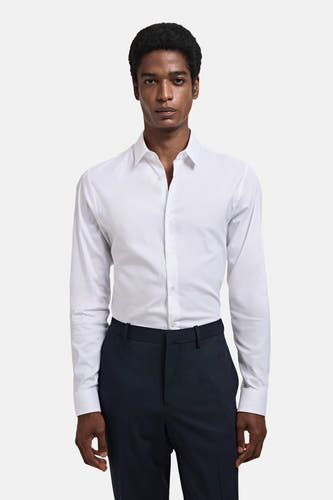 Wit overhemd met lange mouwen van MANGO, gedragen met een donkere pantalon.