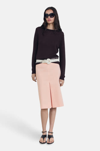 Roze 3/4 rok van MANGO, met een split aan de voorkant, gecombineerd met een riem, trui en sandalen.
