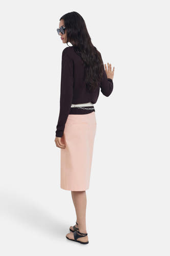 Roze rok 3/4 van MANGO, met een kettingriem om de taille en gecombineerd met een bruine trui.