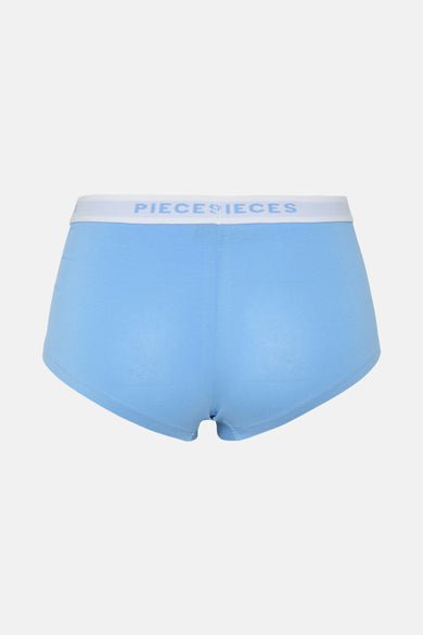 Shorty bleu de PIECES, avec une bande élastique blanche avec le logo de la marque.