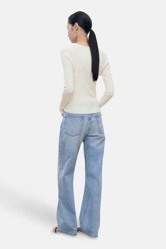 Witte trui met ronde hals van MANGO, gedragen met wijde jeans, achterkant gezien.
