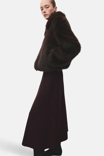 Lange bordeaux rok van MANGO, gecombineerd met een donkerbruine bontjas en zwarte schoenen.
