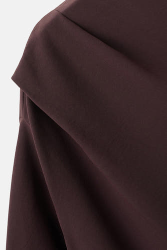 Bruine blouse met lange mouwen van MANGO, met een gedrapeerde halslijn en subtiele textuur.

