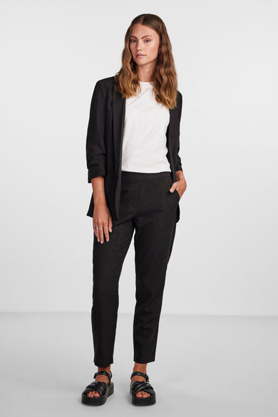 Blazer noir de PIECES, porté avec un T-shirt blanc et un pantalon noir, combiné avec des sandales noires.