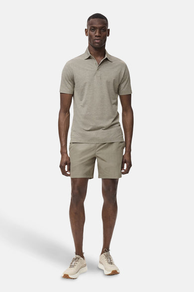 Groene polo met korte mouwen van MANGO, met een effen kleur en gedragen met kaki shorts en crèmekleurige sneakers.