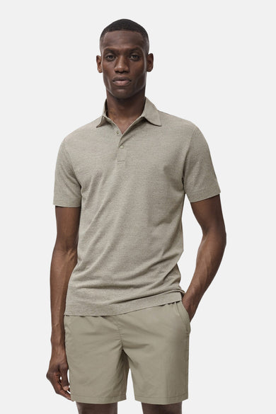 Groene polo met korte mouwen van MANGO, gedragen met kaki shorts, in een neutrale studiopresentatie.
