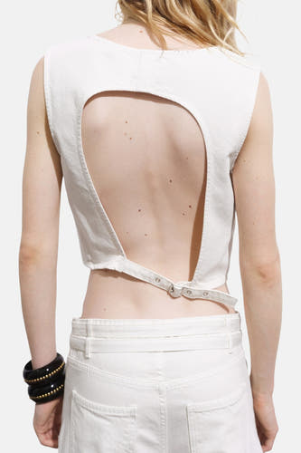 Ecru mouwloze blouse van MANGO, met open rug en verstelbare band op de rug, gecombineerd met een witte broek en armband.