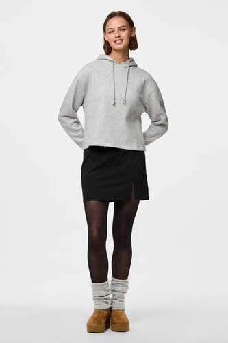 Pantys noirs de PIECES, portés avec une jupe noire fendue et des chaussures à plateformes marron avec chaussettes.