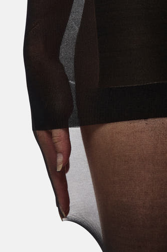 Panty noir de PIECES®, en tissu transparent et une main visible avec des ongles dorés.