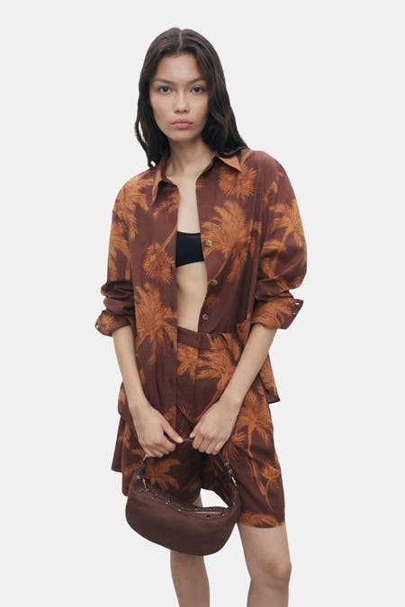 Bruin overhemd met lange mouwen van MANGO, met een bruine palmbomenprint, gedragen met een zwarte bh.