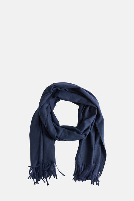 Châle d'hiver bleu de MANGO, présenté roulé avec des franges.