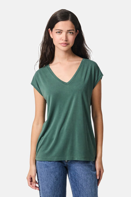 Groen T-shirt van PIECES®, met korte mouwen en een V-hals, gedragen met een jeansbroek.
